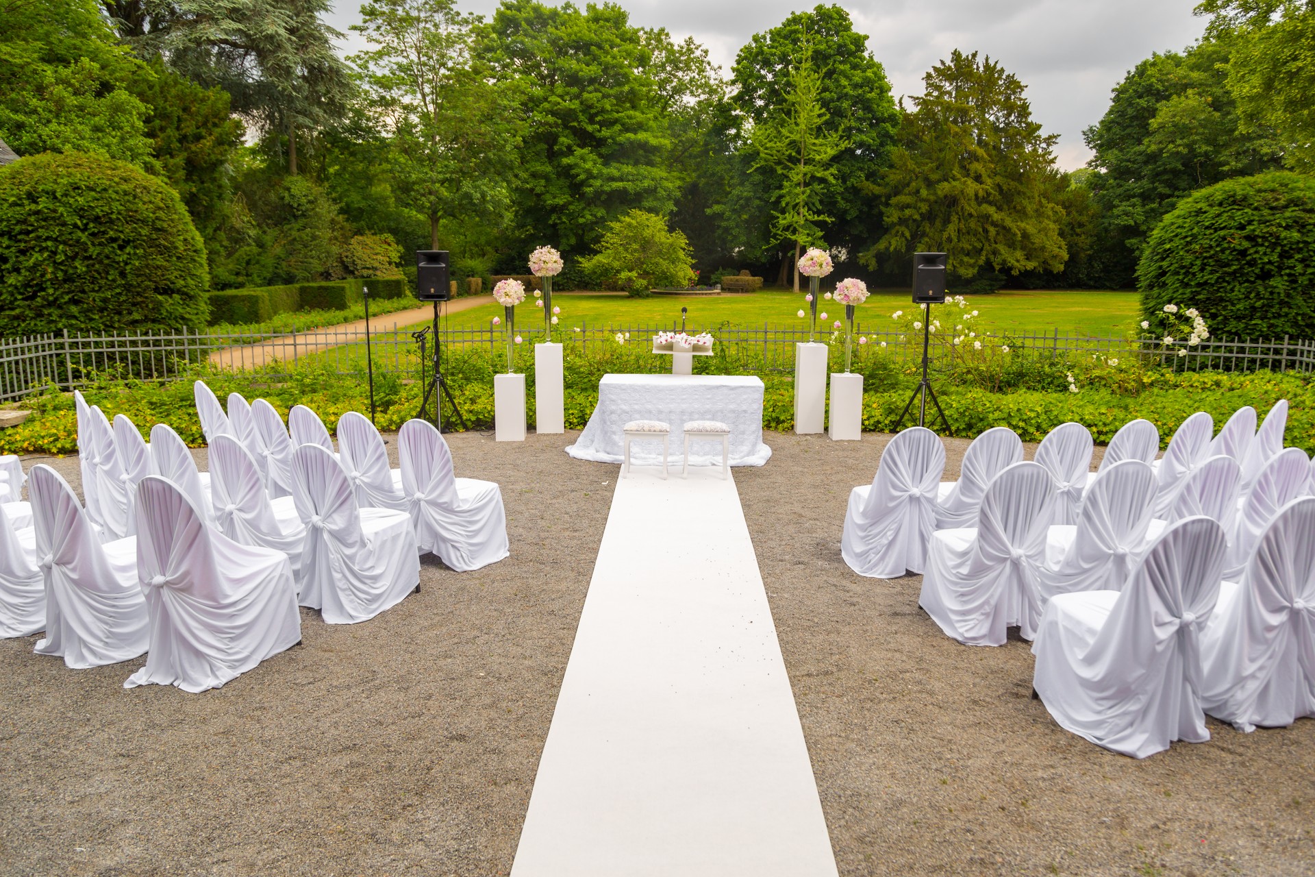 Scenery of the wedding ceremony in the park. White frame decorated with flowers. Ceremony in white style