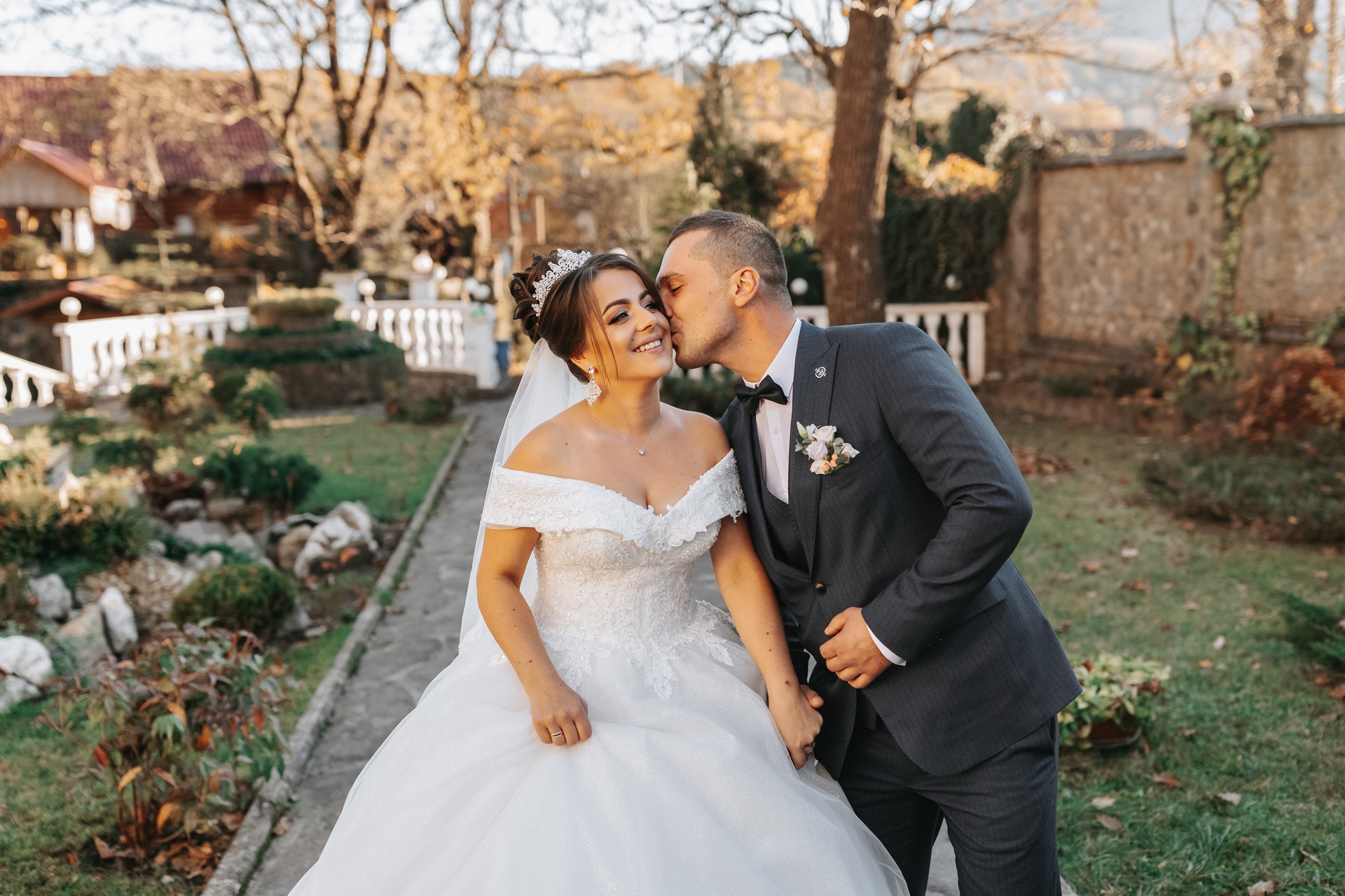 The groom holds the bride's hand and walks. of the bride against the background of the sun's rays, the park and the forest.